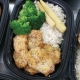 Oven baked breaded chicken breast with lemon sauce served with rice and vegetables